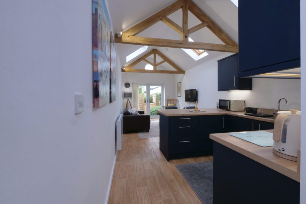 Award-winning Garden Cottage: open-plan kitchen under exposed timber trusses