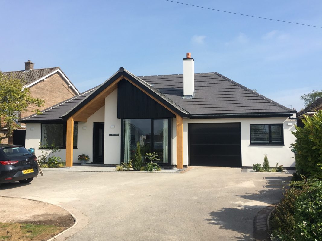 Remodelled bungalow with a glazed gable and dark timber cladding